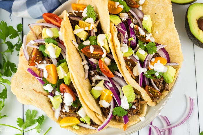 Enjoy Crock pot shredded beef tacos loaded with tender beef. The slow cooker does all of the work and all you need to do is add your favorite toppings! 