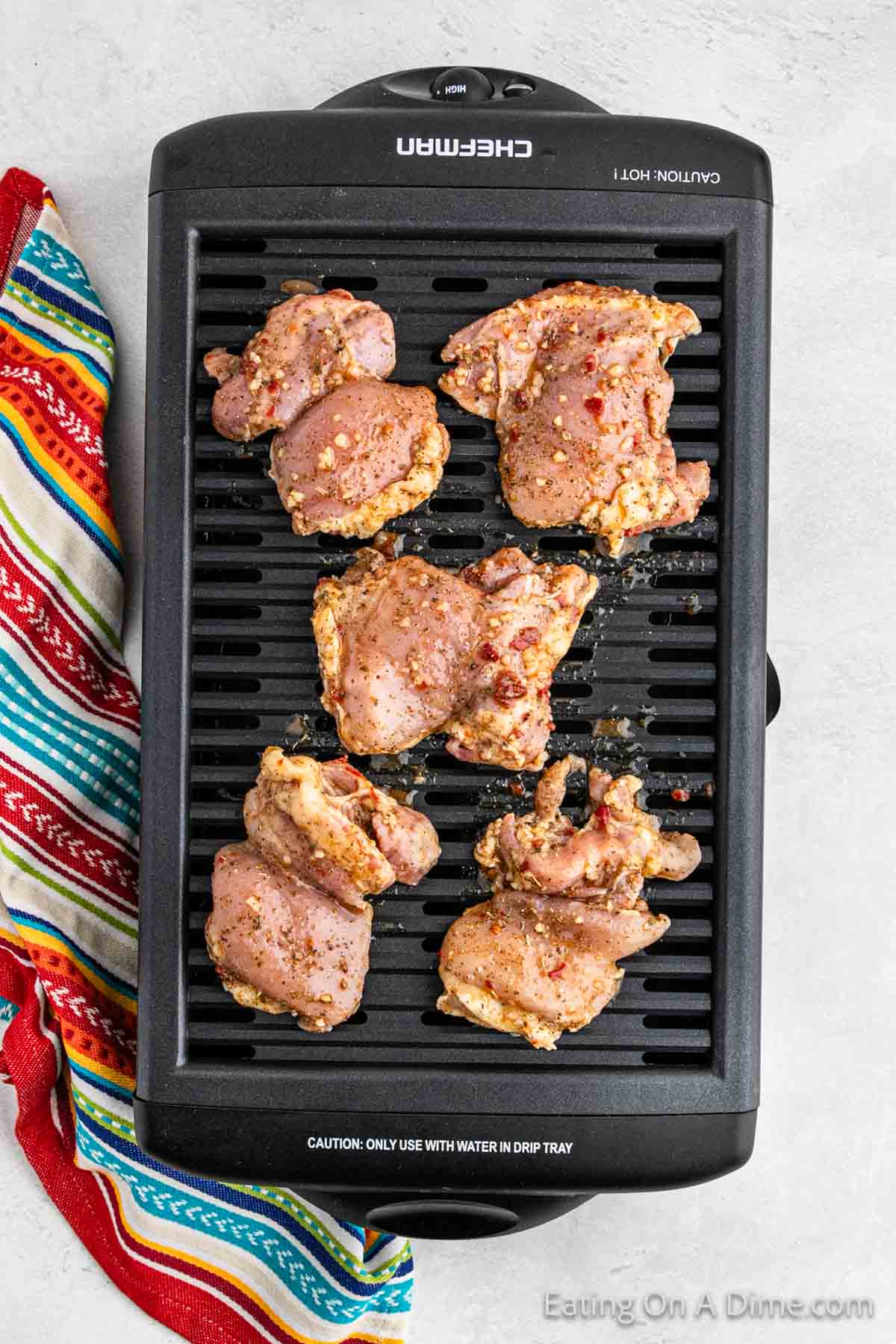 Indoor grill with marinated chicken thighs on top