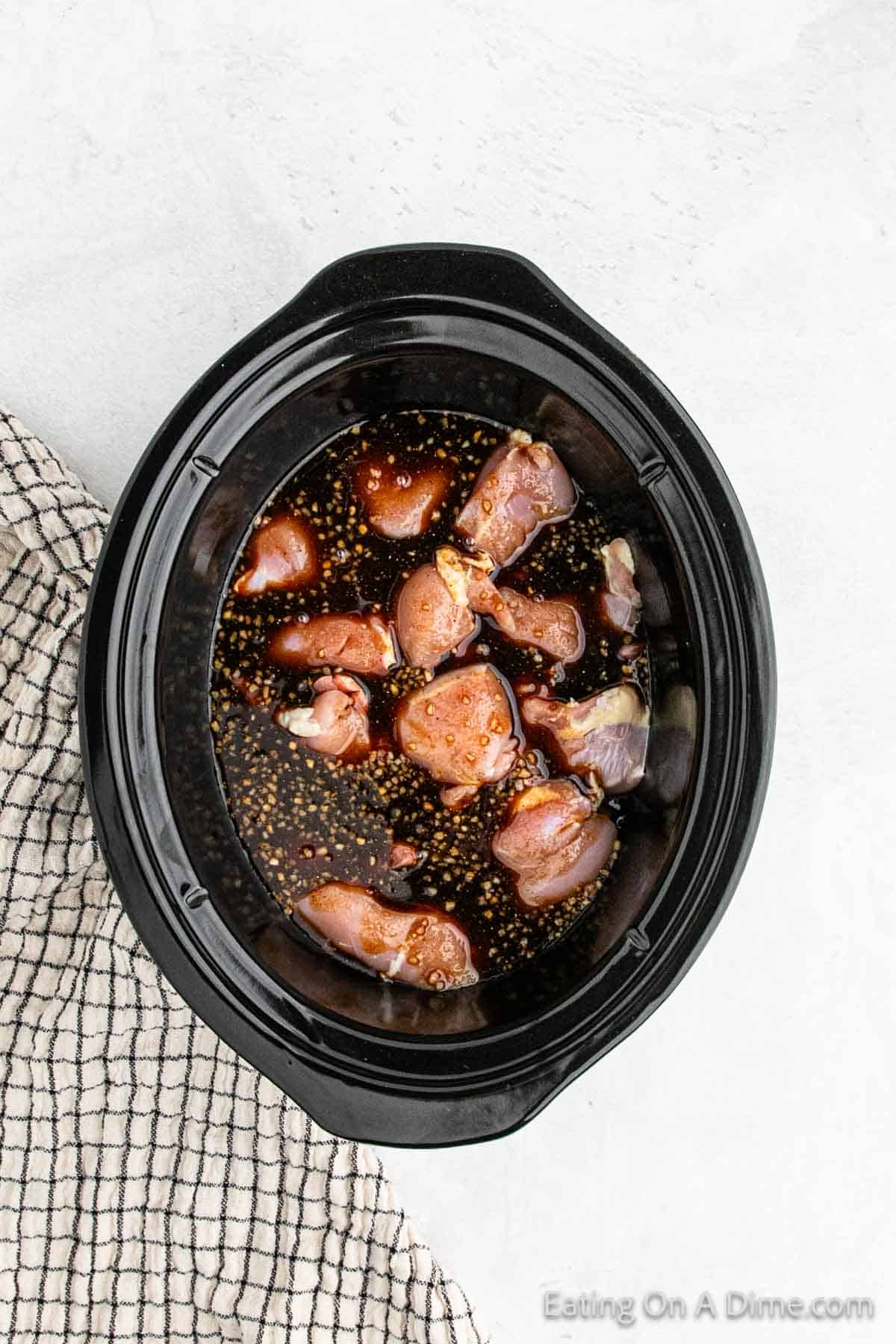Chicken thighs in a slow cooker topped with the soy sauce mixture