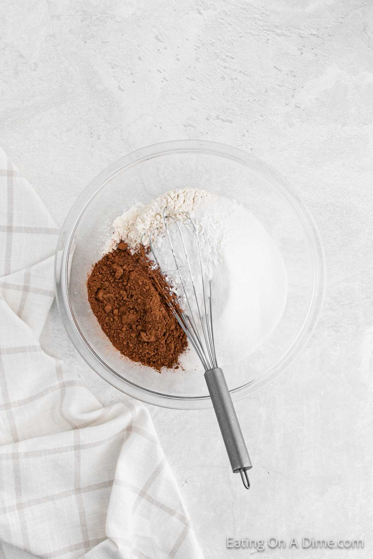 Whisking together flour, sugar, and cocoa powder in a bowl