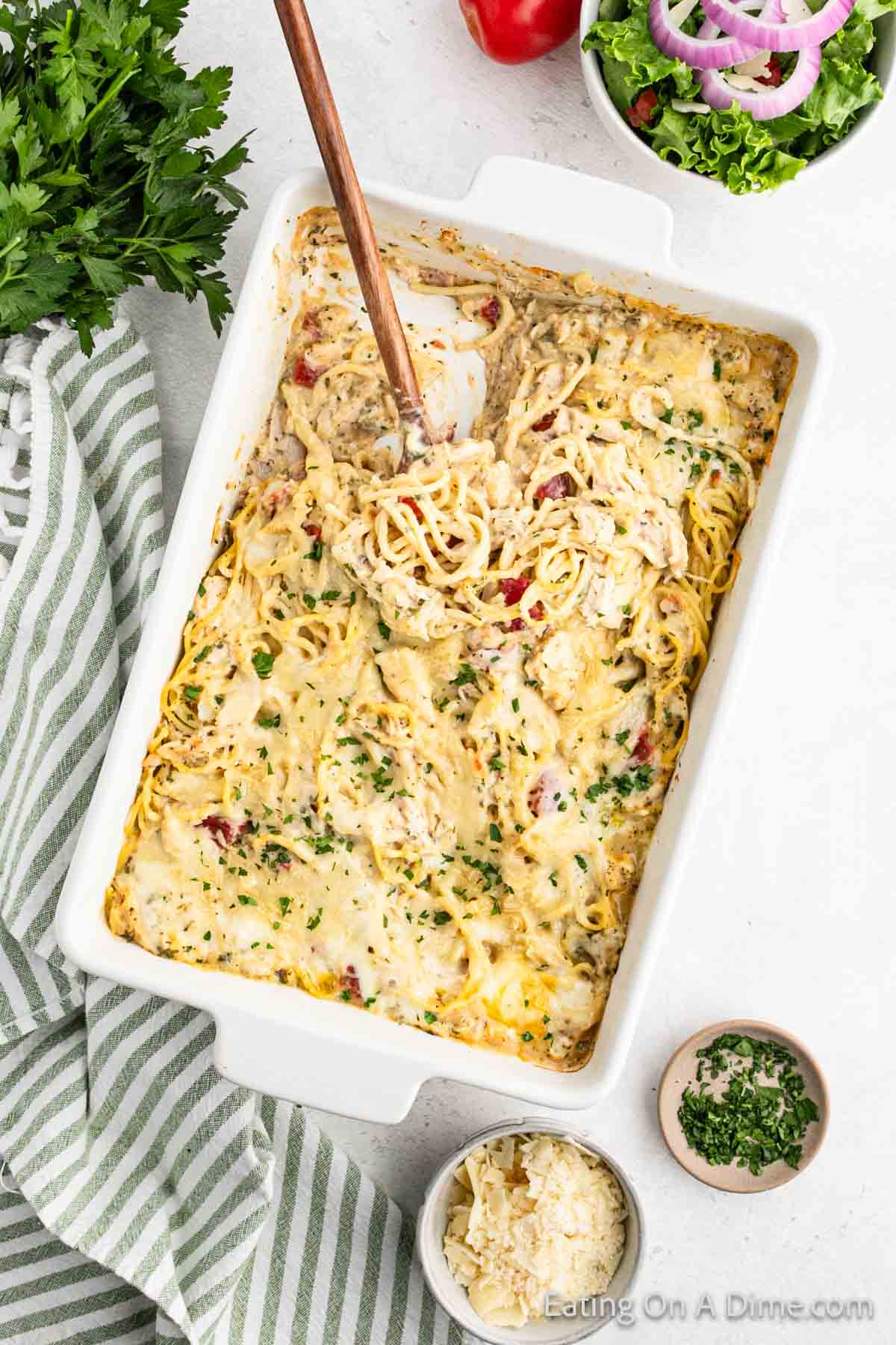Chicken Spaghetti Casserole in a baking dish with a wooden spoon