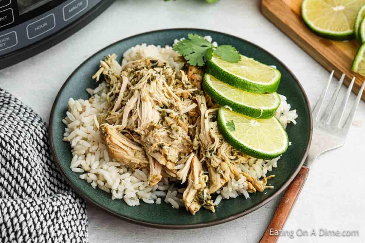 Mojo Chicken on a plate with white rice and fresh lime slices