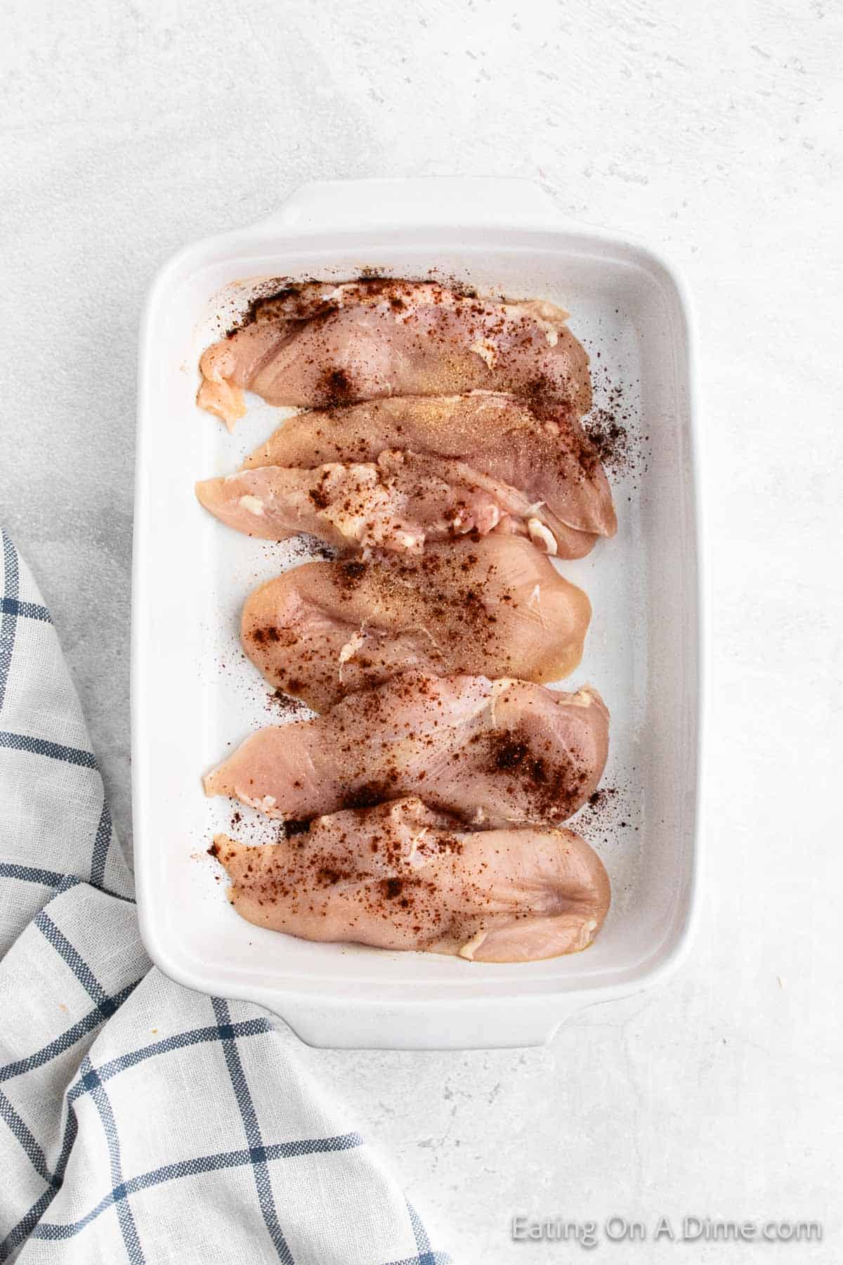 Chicken breast in a baking dish topped with chili powder 