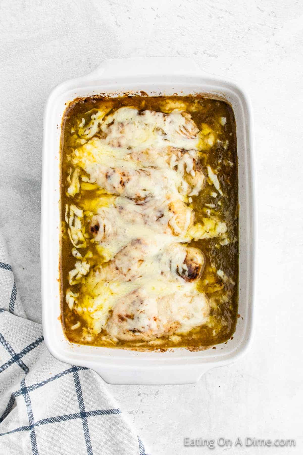Baked chicken enchiladas in a baking dish topped with melted cheese