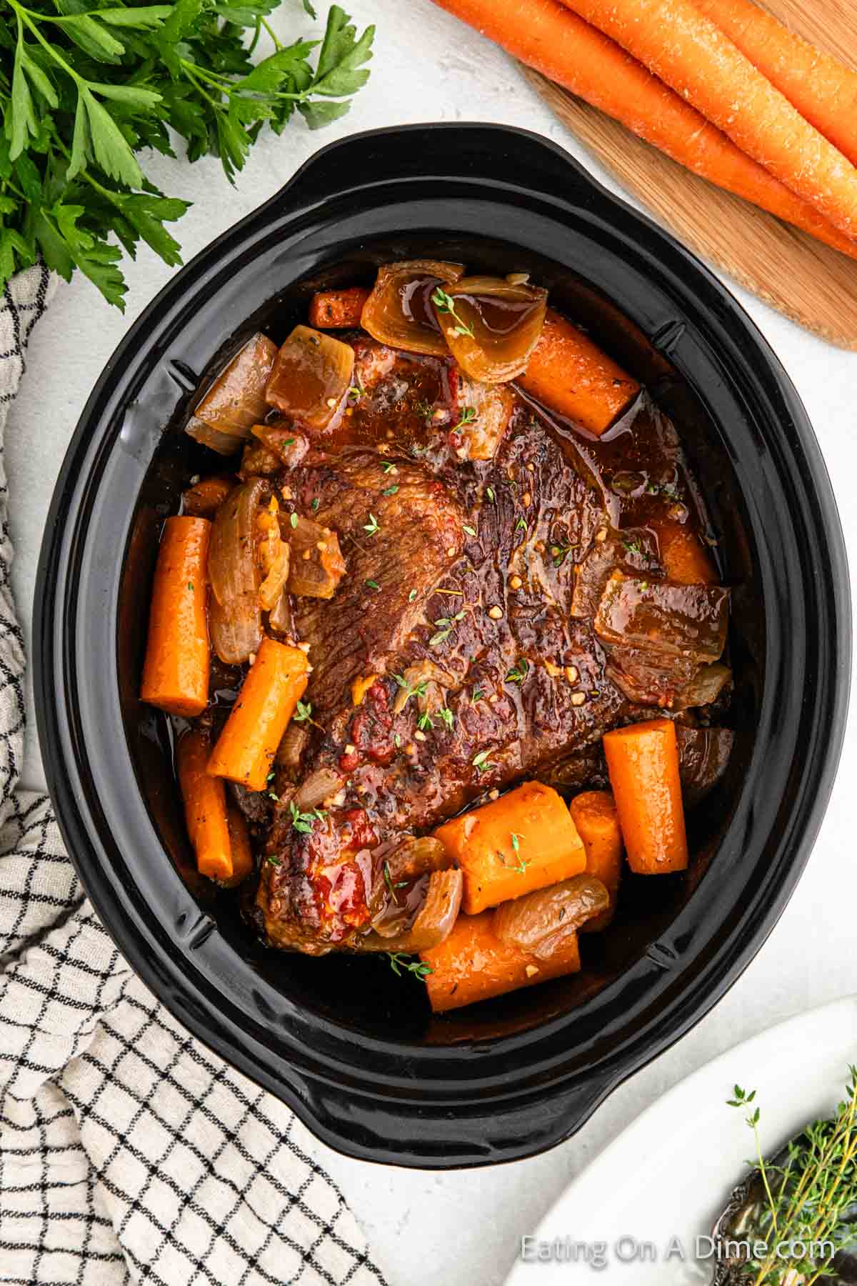 Cooked brisket in a slow cooker with carrots and onions