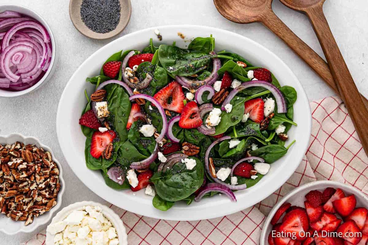 Fresh spinach strawberry salad in a white bowl