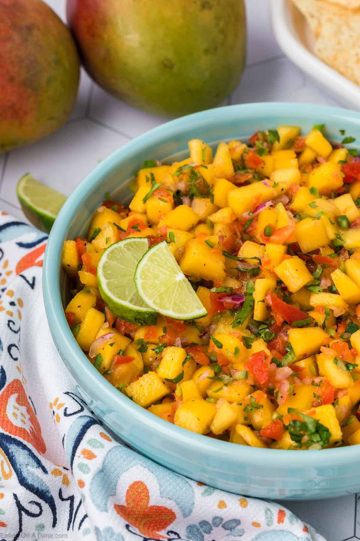 Mango Salsa in a bowl topped with lime wedges
