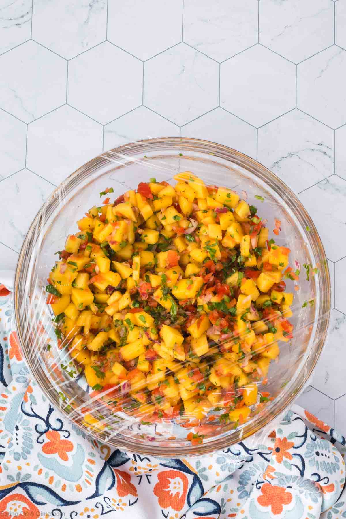 Mango Salsa on a bowl covered with plastic wrap