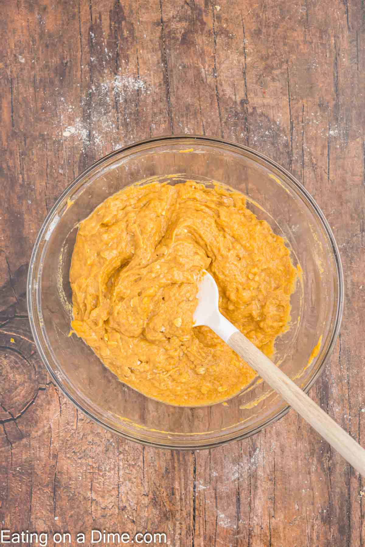 Mixing the pumpkin ingredients together with the dry ingredients in a bowl with a spoon