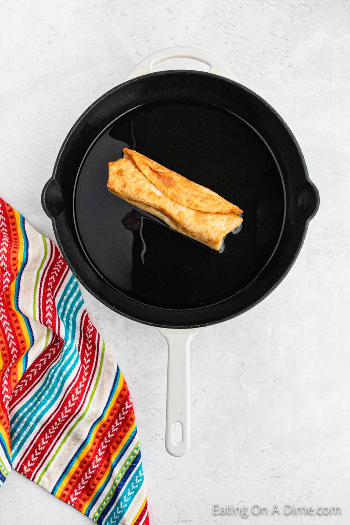 Crispy tortilla in a large skillet with oil