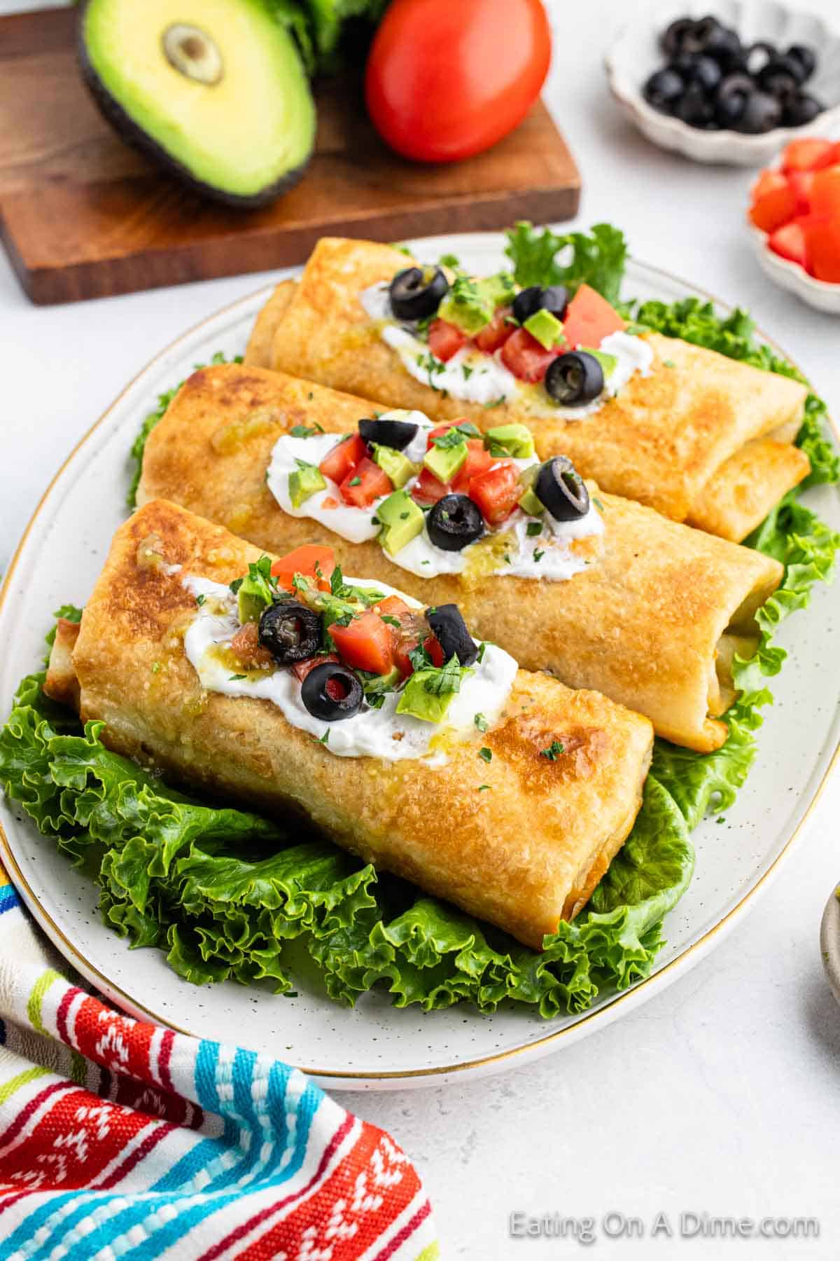 3 Chimichangas on a lettuce on a platter