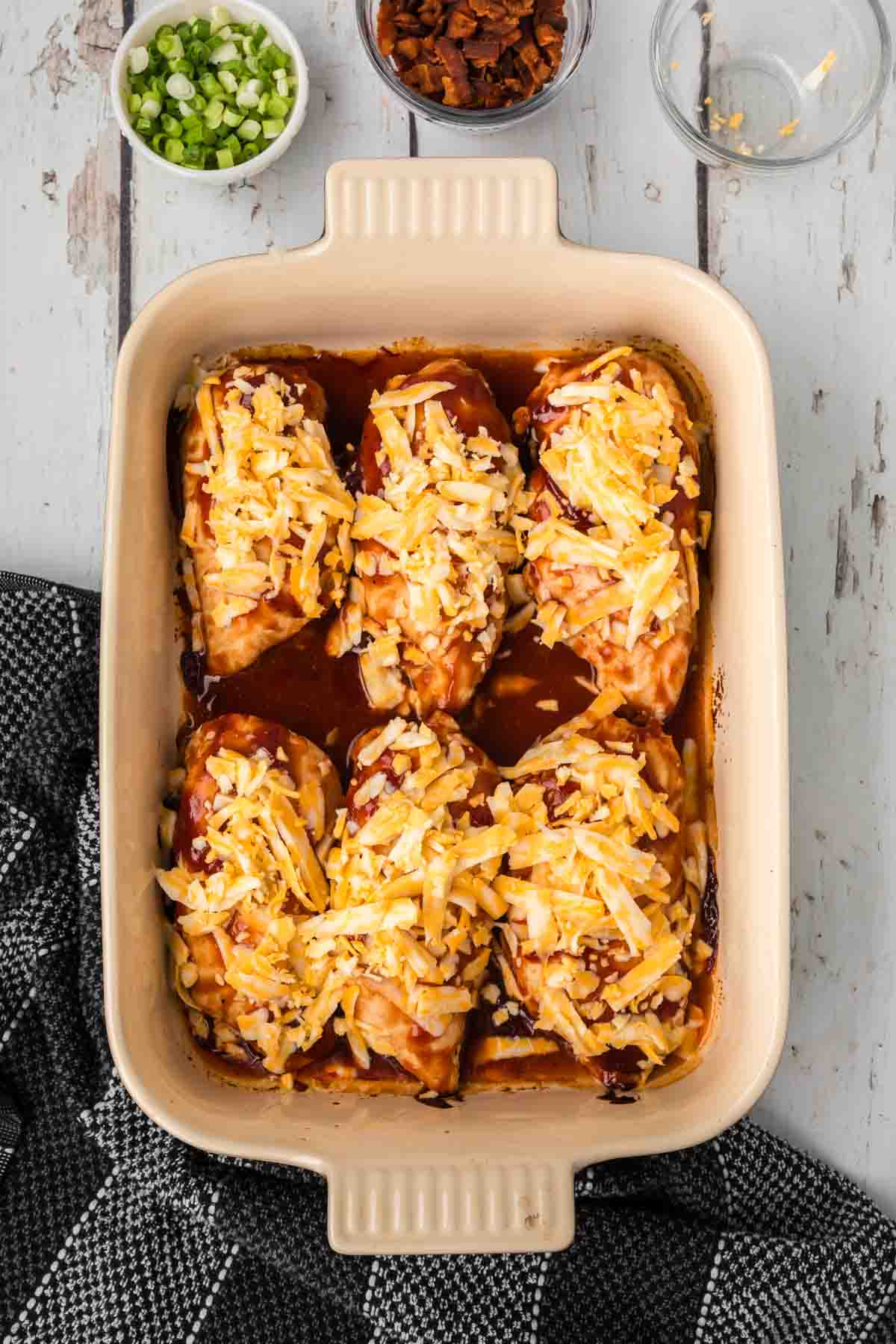BBQ Chicken Breast in a baking dish and topped with shredded cheese