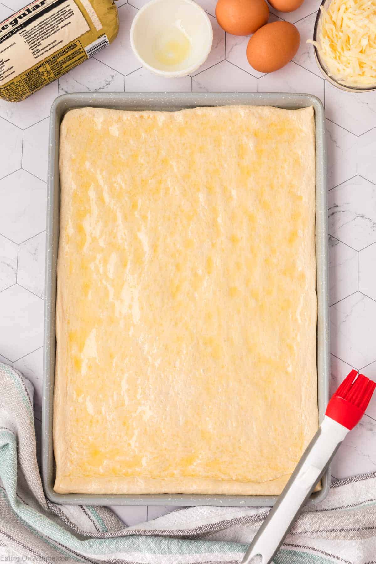 Spreading oil on the pizza dough on a baking sheet