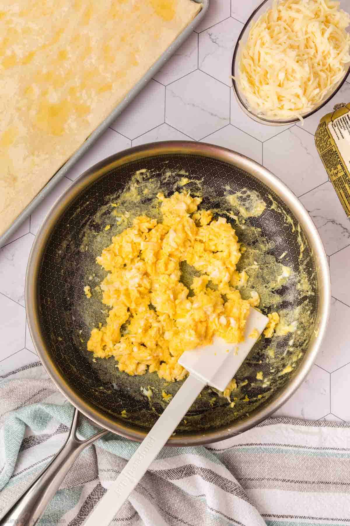 Scrambling eggs in a skillet with a spatula