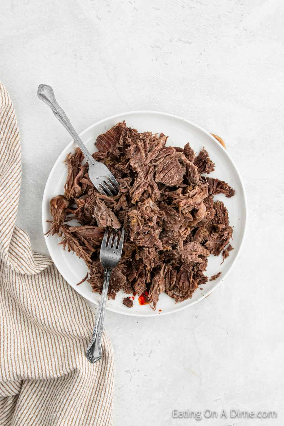 Shredded beef on a plate with two folks