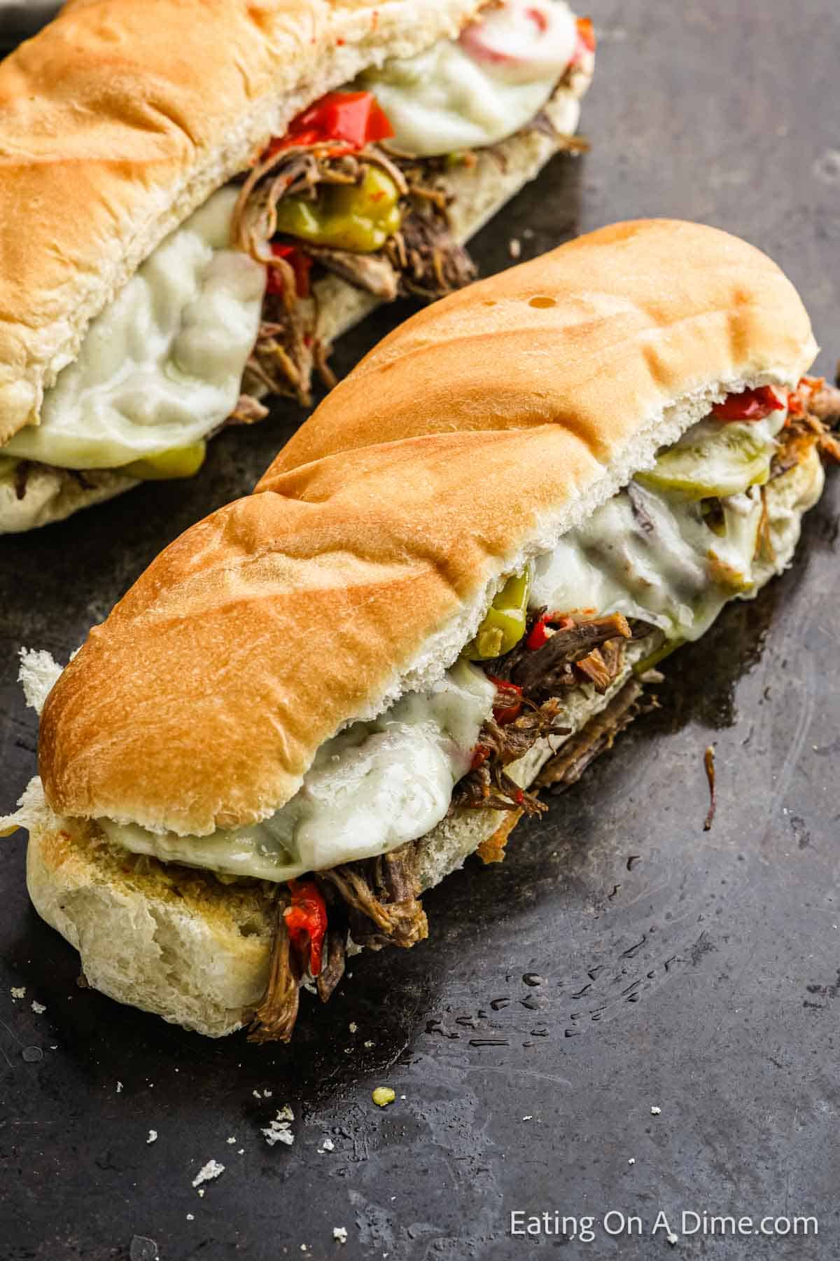 Italian Beef Sandwich topped with melted cheese and peppers and shredded beef