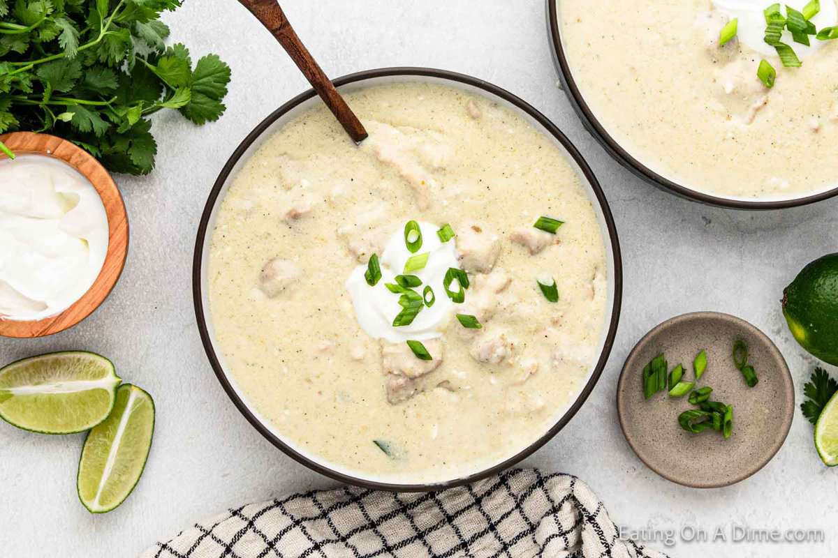 Keto Chicken Enchilada Soup in a bowl with a side of lime wedges