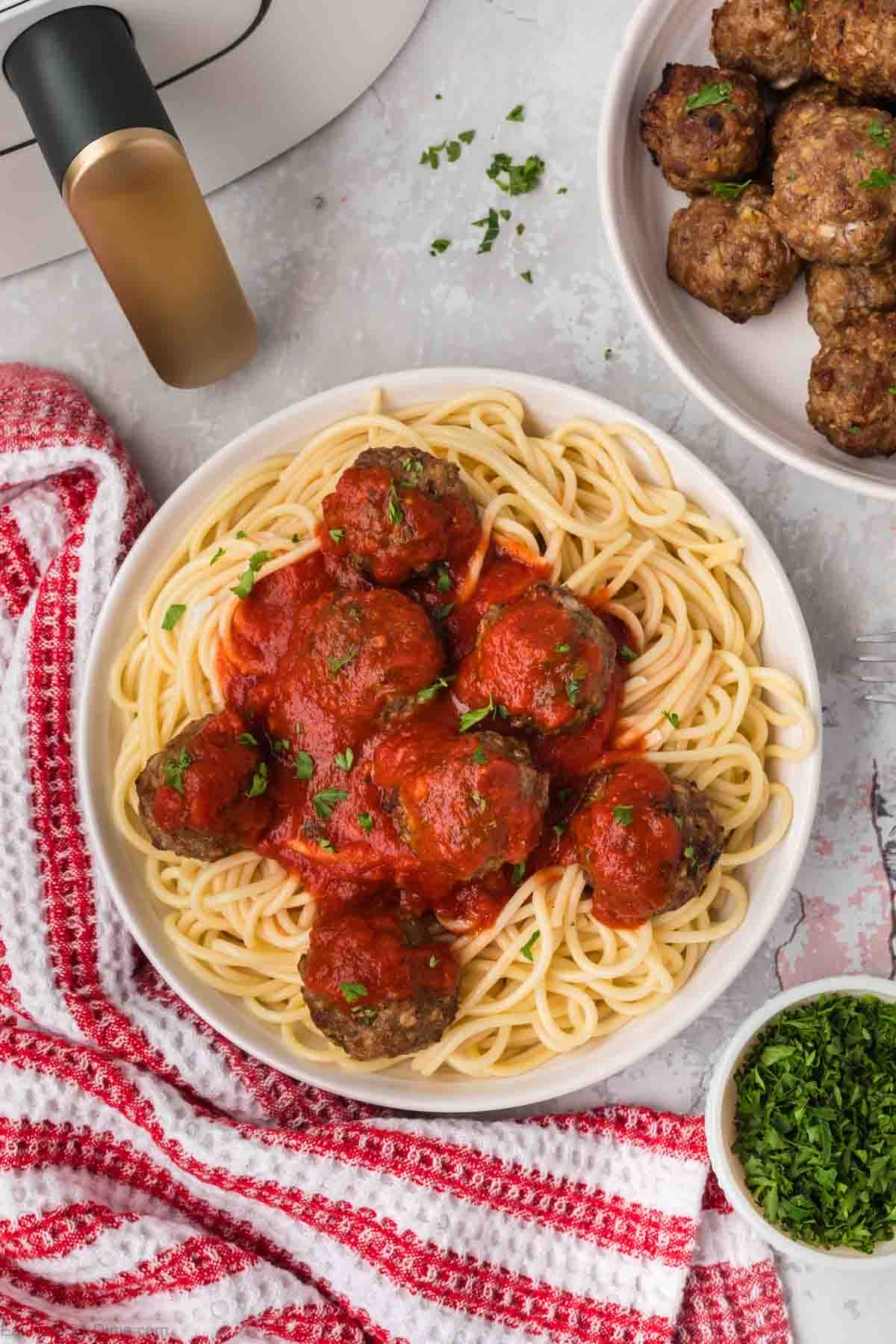 Meatballs covered in sauce on spaghetti noodles in a bowl