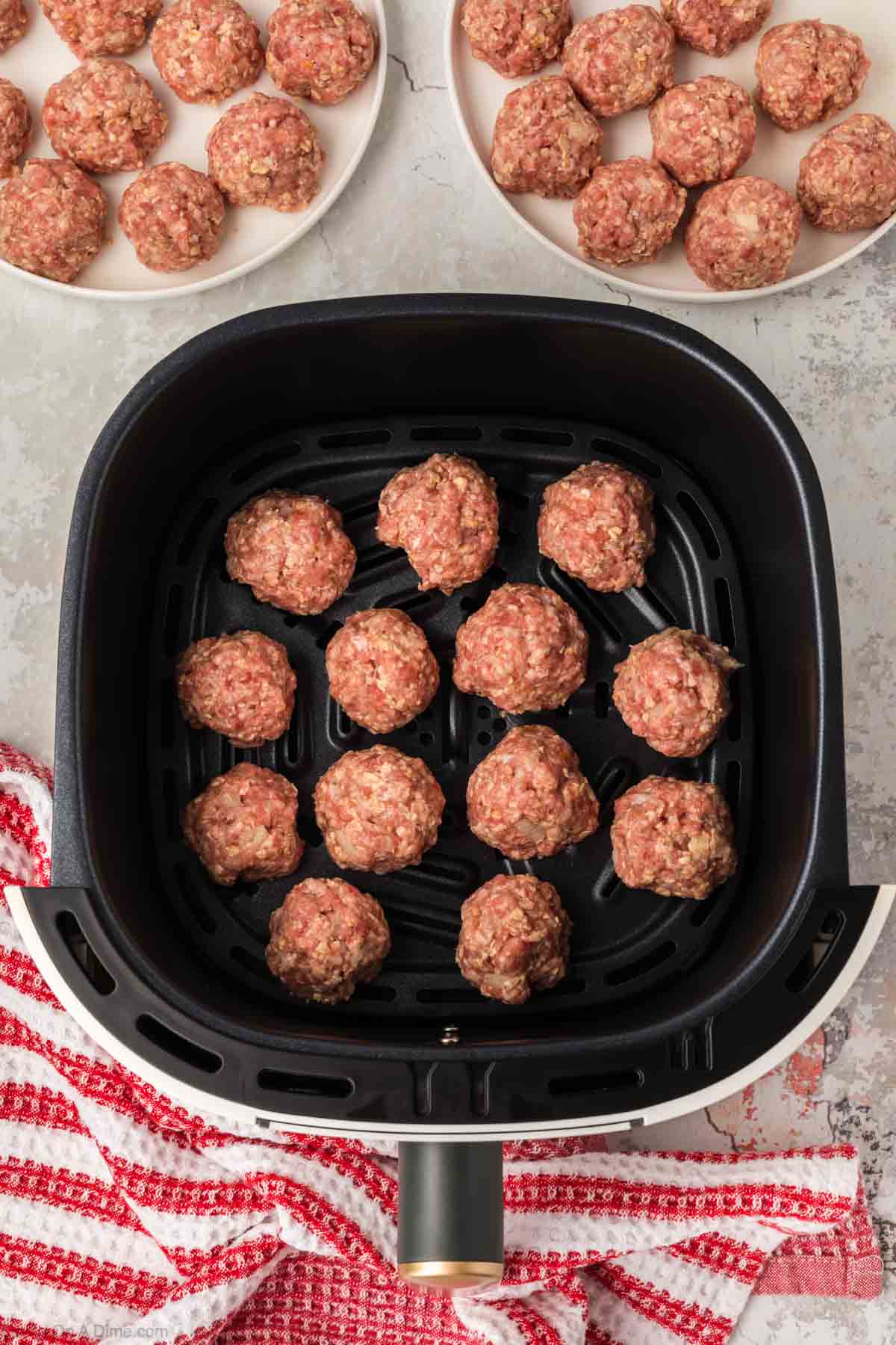 Placing the meatballs in the air fryer basket