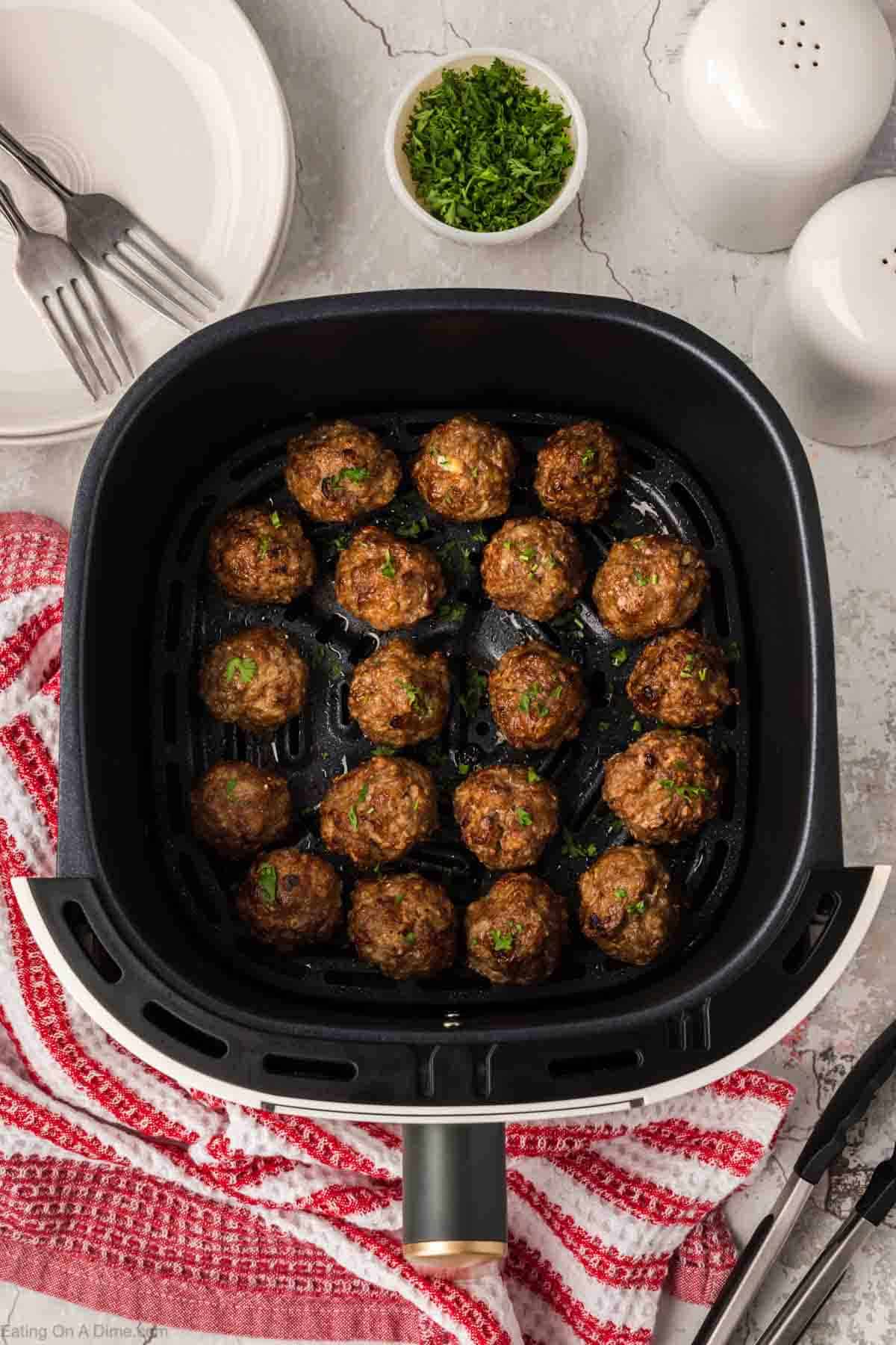 Cooked meatballs in an air fryer basket