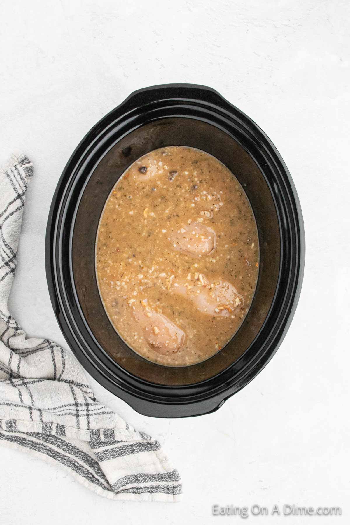 Top the chicken breast with the cream of mushroom mixture in the slow cooker