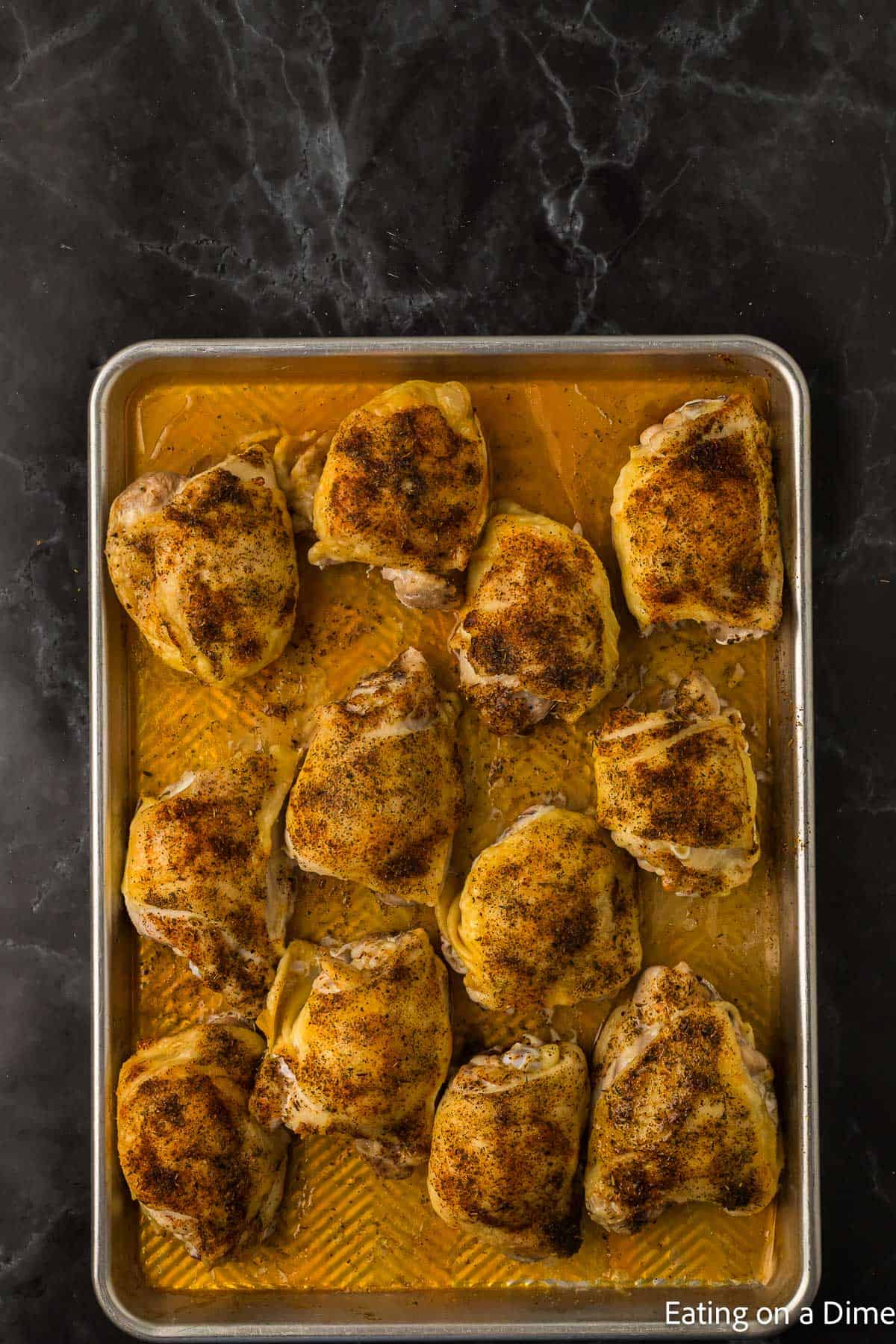 Cooked seasoned chicken thighs on a baking sheet