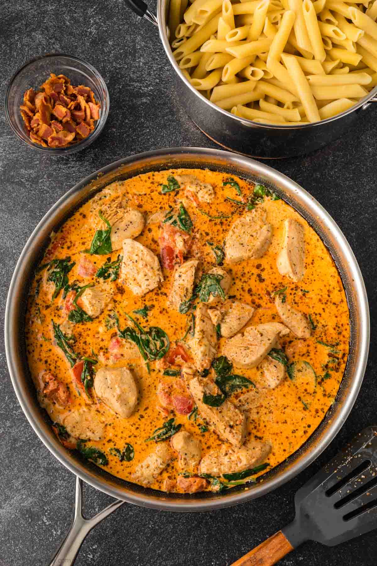 Heavy cream mixed into the chicken with spinach and seasoning in a large skillet