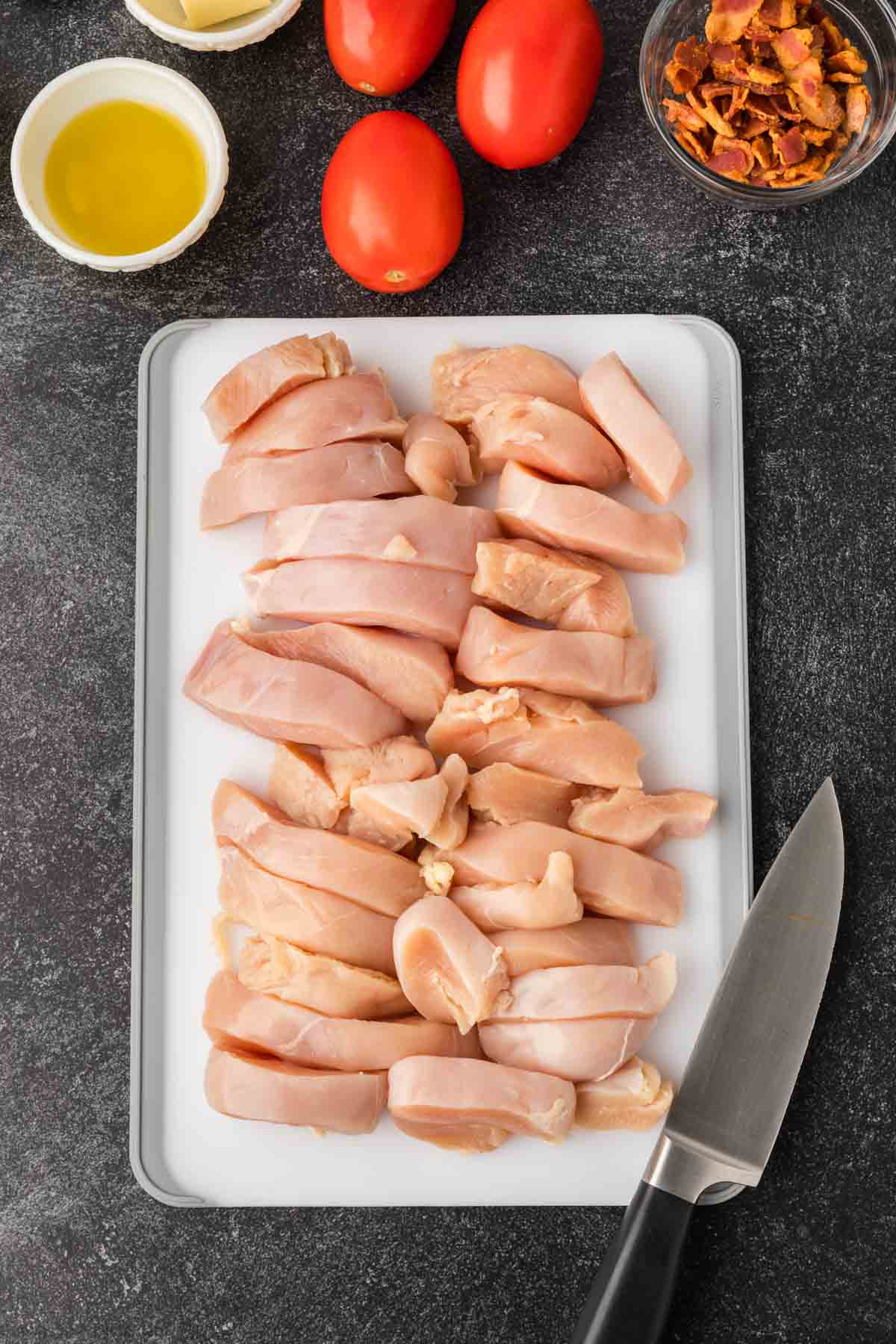 Uncooked chicken strips on a cutting board