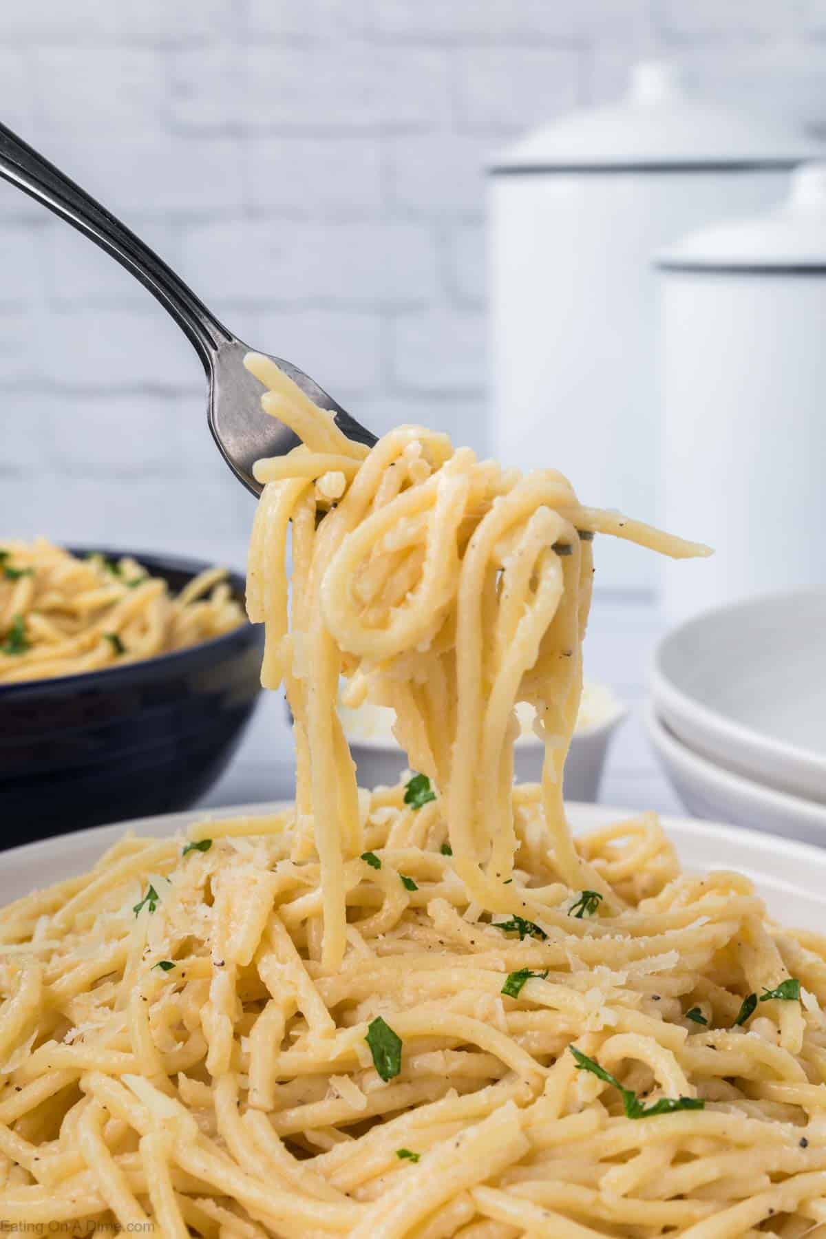 Creamy garlic parmesan pasta on a plate with a bite on a fork