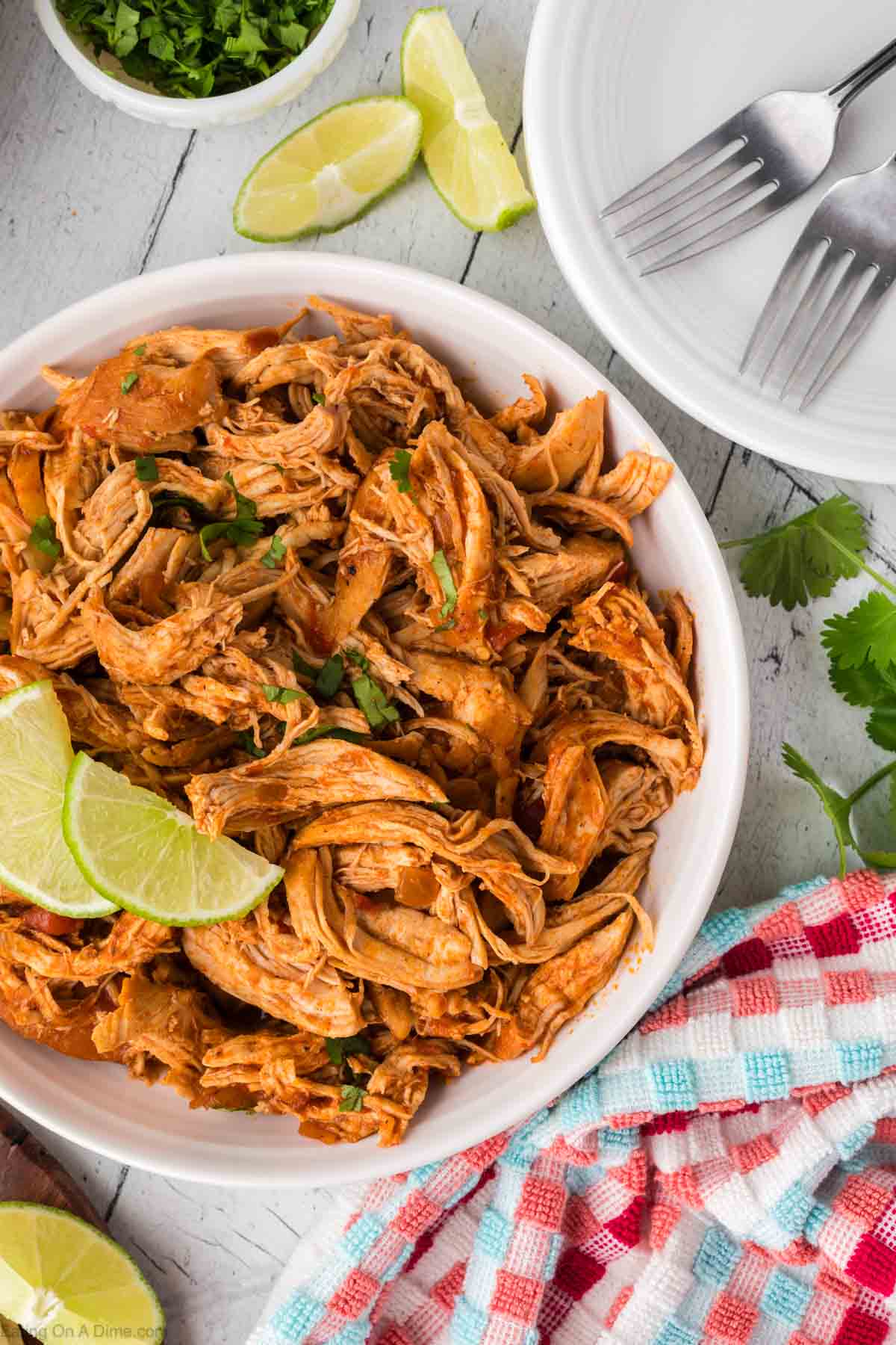 Mexican Shredded chicken in a bowl topped with fresh lime wedges