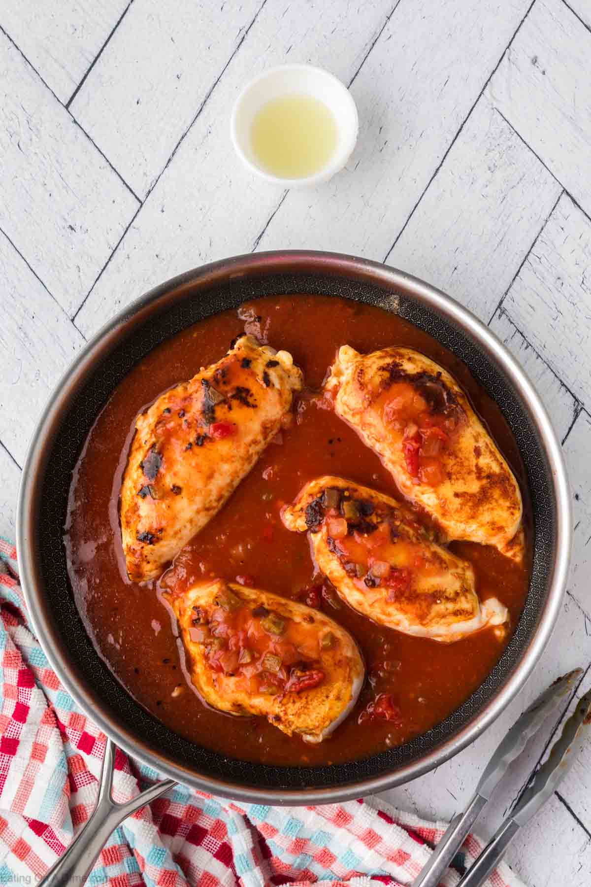 Cooked chicken breast in a skillet with salsa 