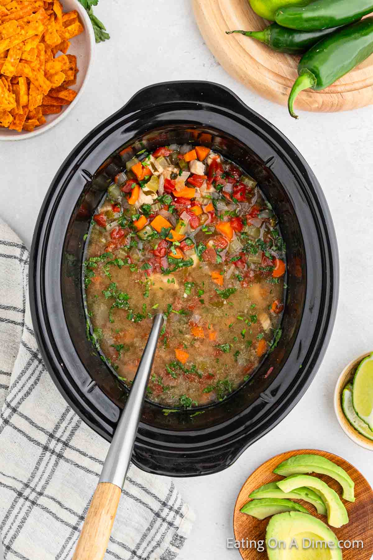 Cooked Mexican Chicken Soup in a slow cooker with a ladle