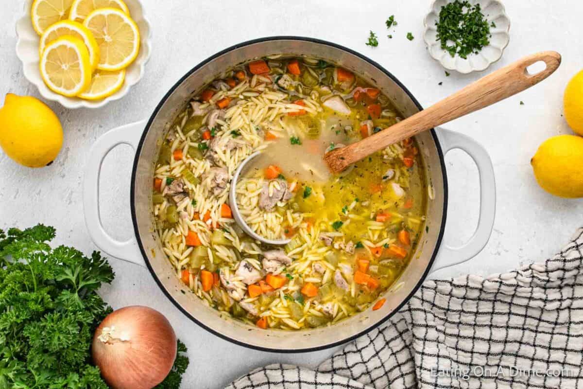 Lemon Chicken Orzo Soup in a large pot with a ladle