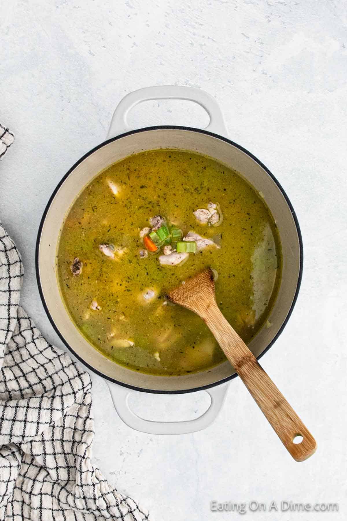 Stirring in the broth with the chicken, veggies, and seasoning