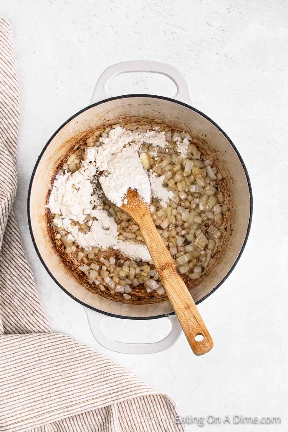 Adding flour to large pot with cooked onions