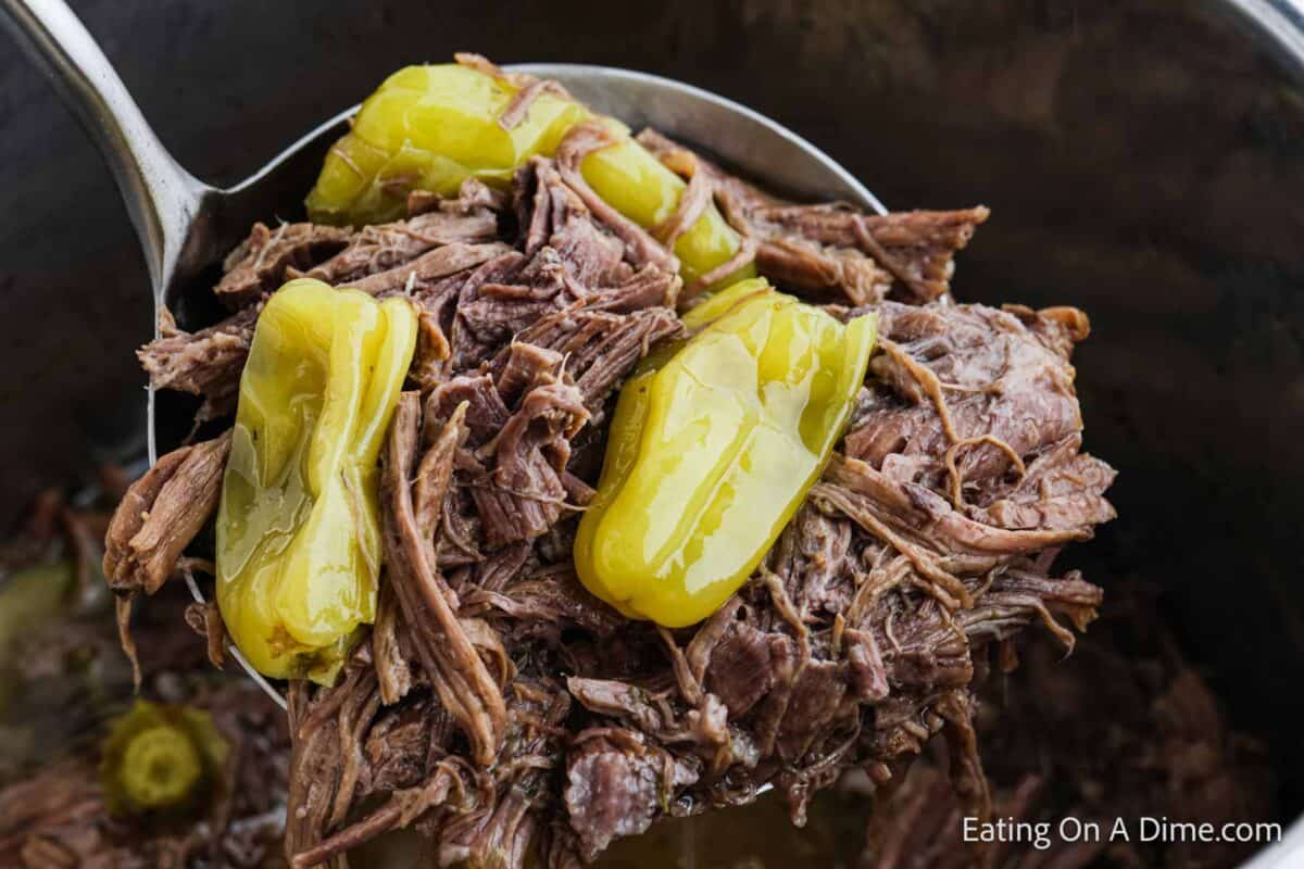 A ladle full of shredded beef with Pepperoncini Peppers