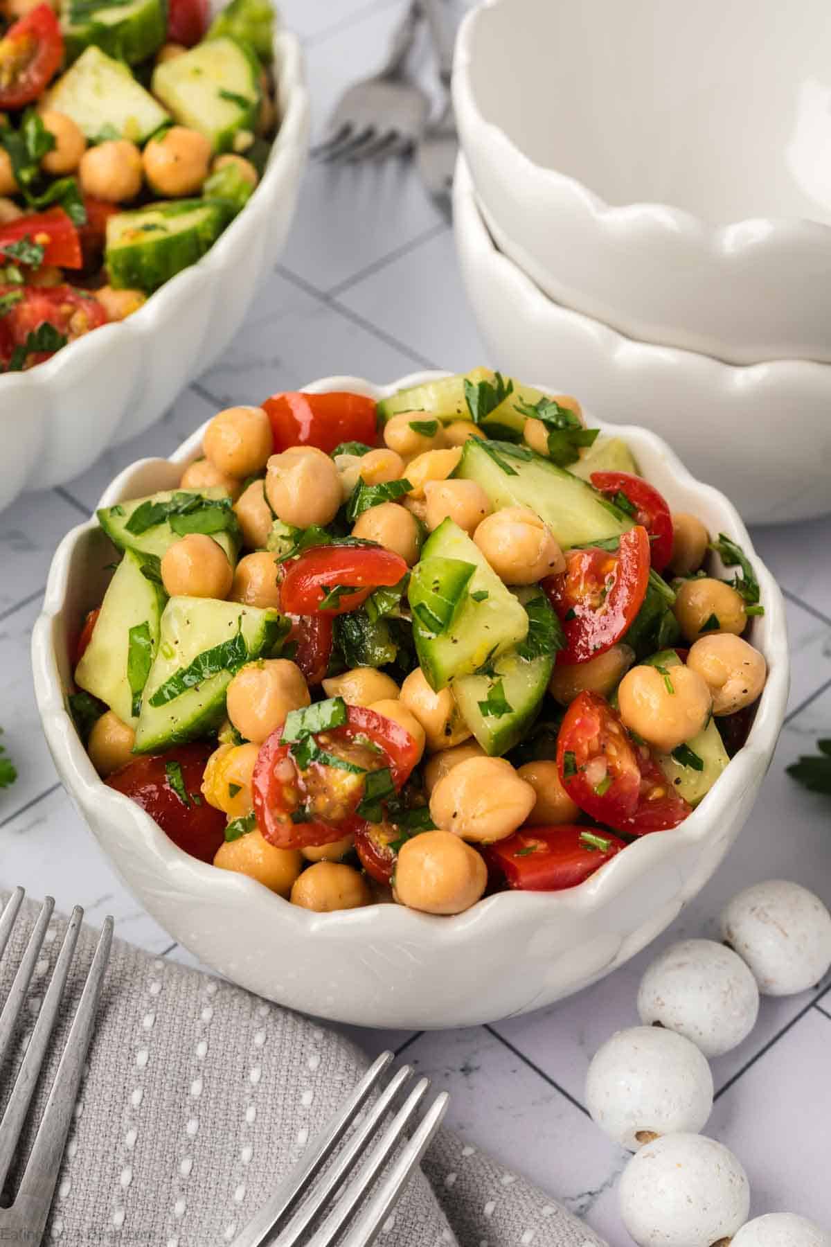 Chickpea Salad topped cucumber, cherry tomatoes, and chickpea in a white bowl