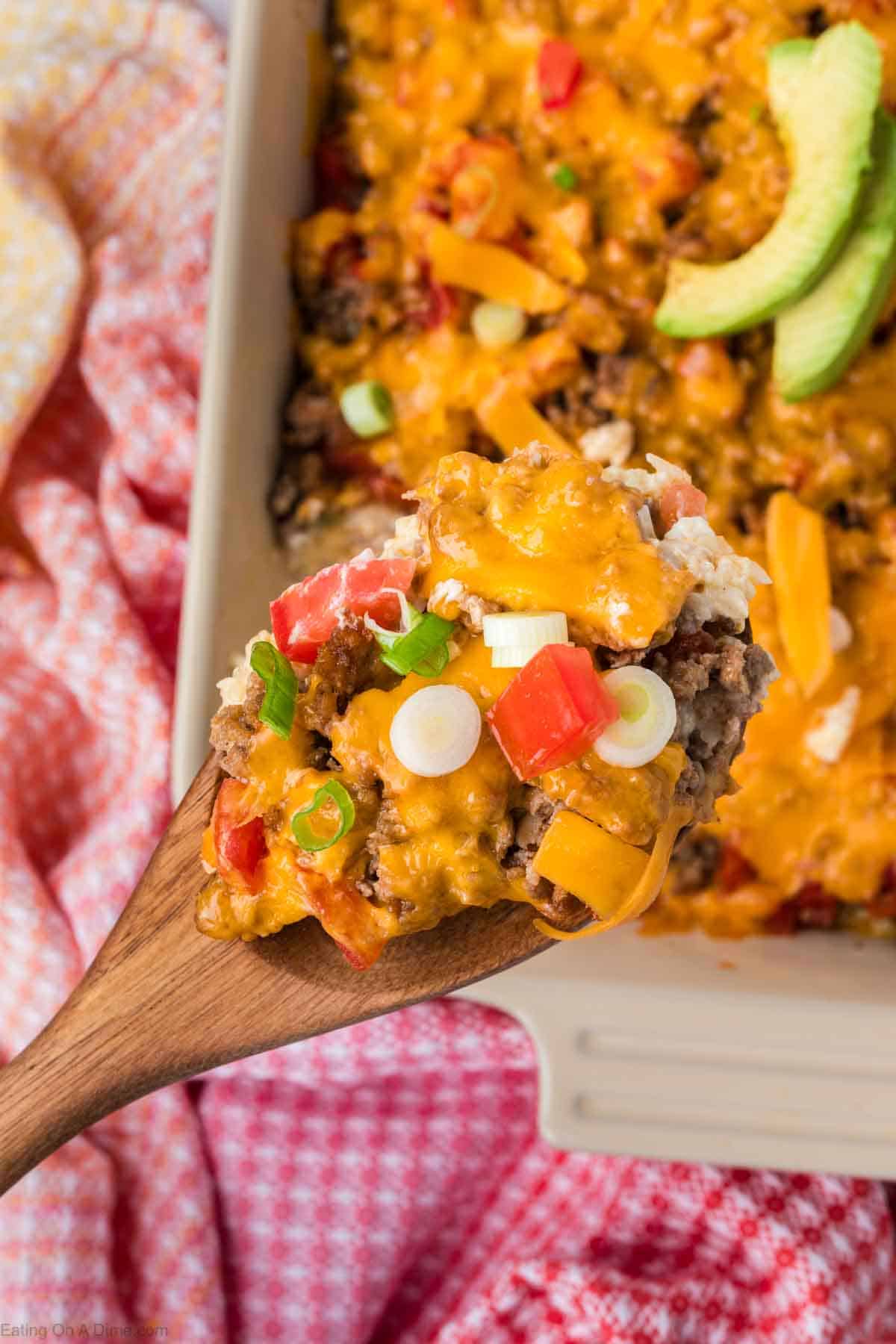Keto Taco Casserole in a baking dish with a serving on a wooden spoon