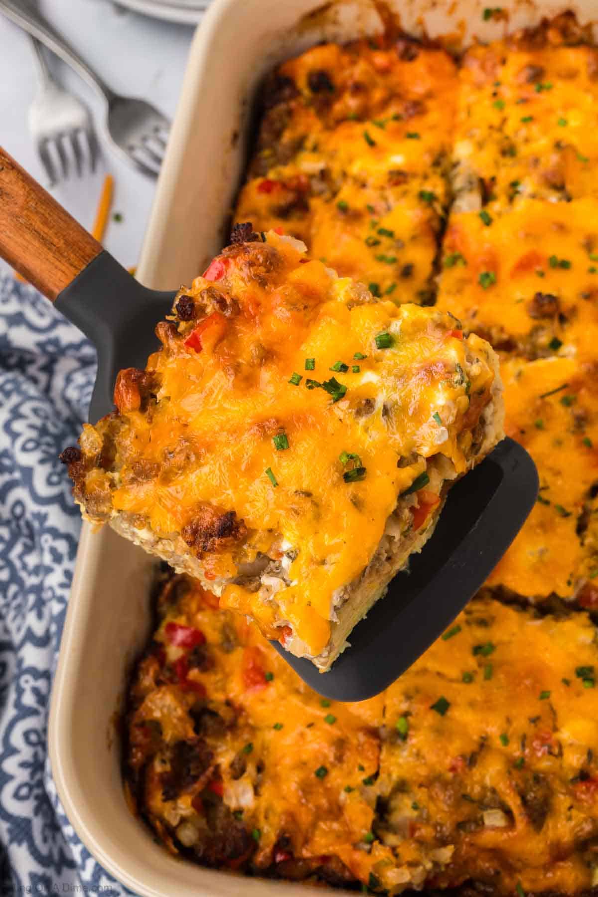 Sausage and Egg Casserole in a baking dish with a serving on a spatula