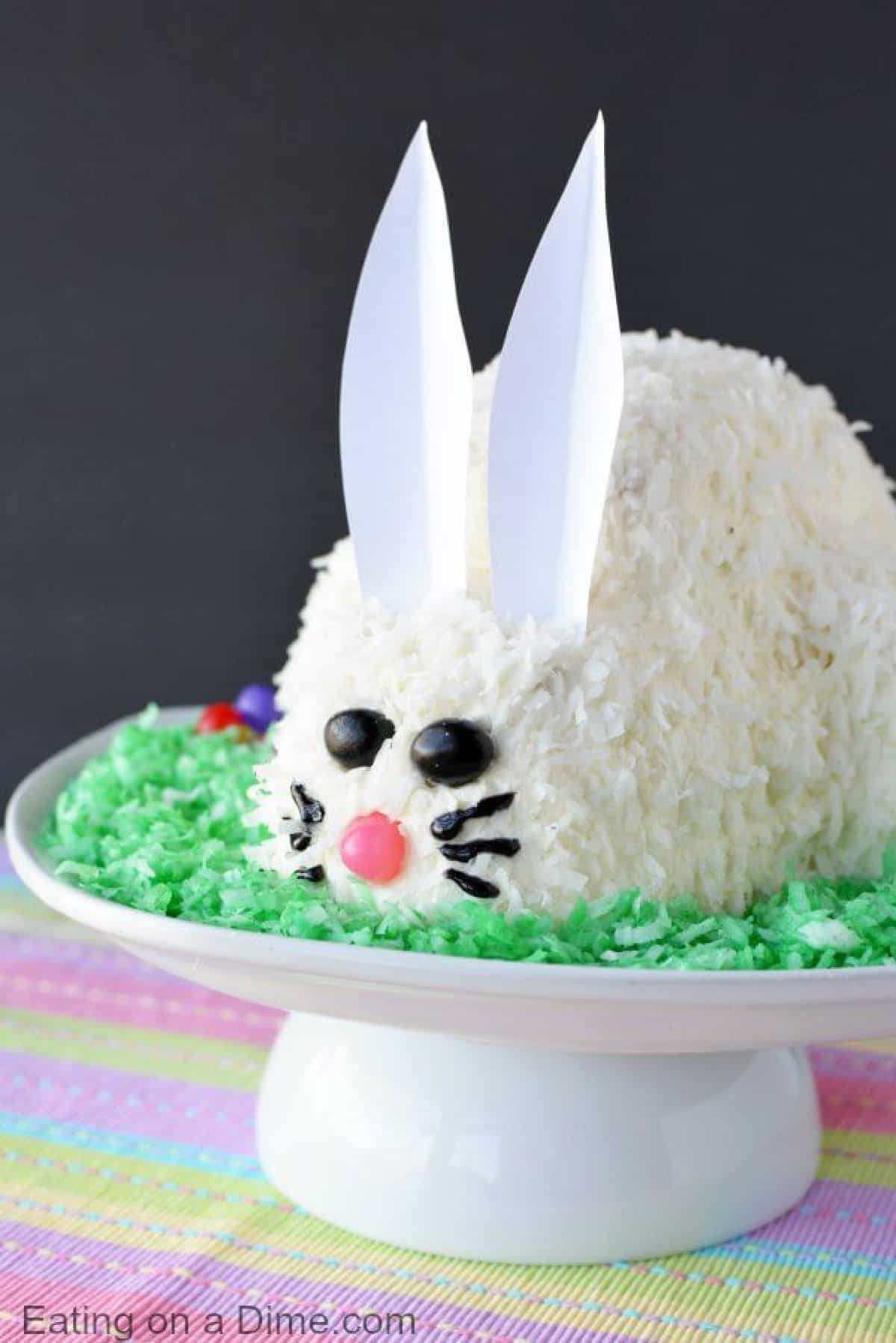 This adorable Easter Bunny Cake will be a hit! You will love how simple this easy bunny cake is. The flaky coconut and jelly beans come together to make this bunny cake recipe so cute! Try this Easter cake recipe! We love easy Easter cakes! 