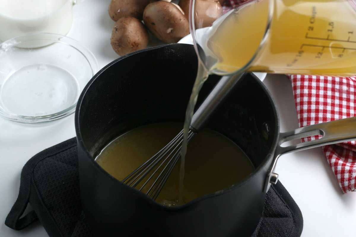 Pouring broth in a sauce pan with a side of mushrooms