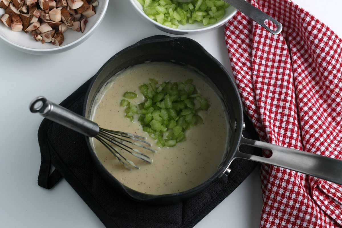 Stirring in the celery in the saucepan with the creamy mixture with a wisk