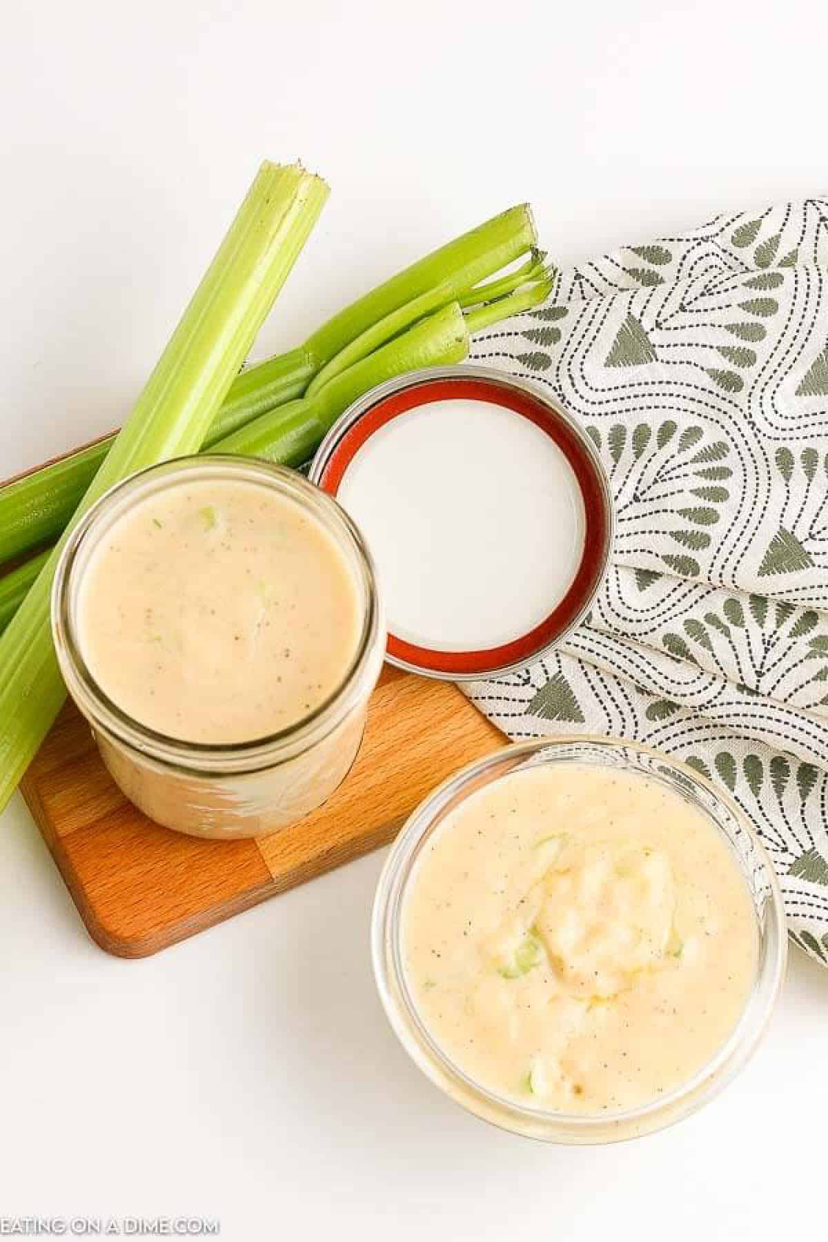 Cream of celery soup in a clear jar with a side of celery sticks 