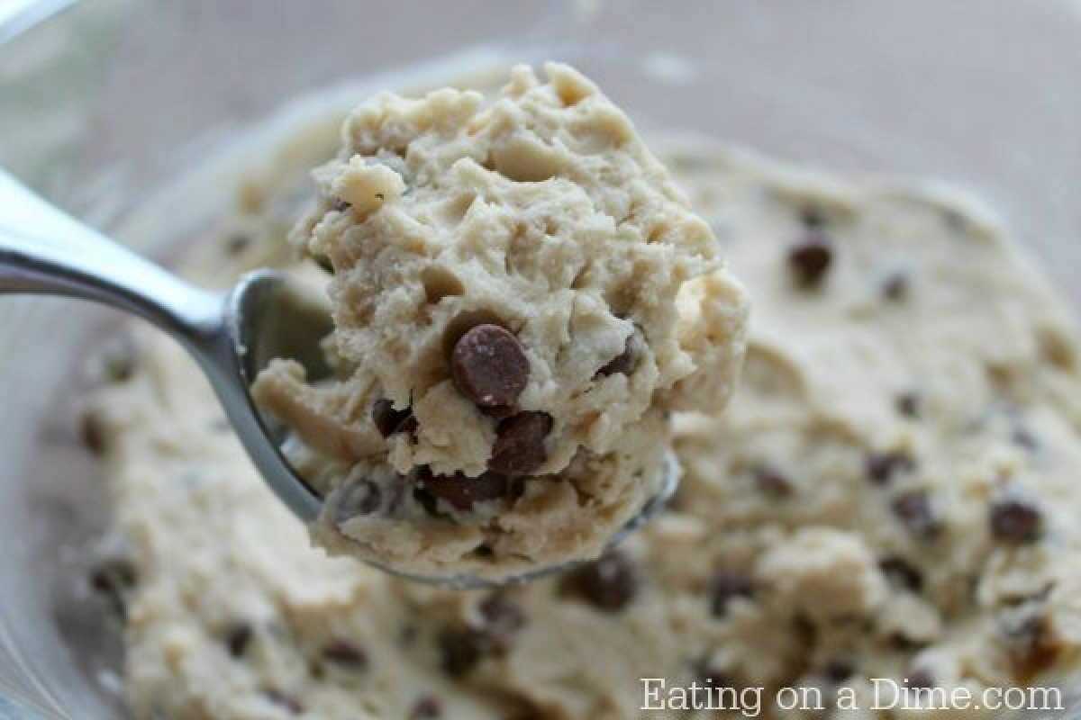 A close-up reveals a spoon scooping creamy chocolate chip cookie dough from a bowl, perfect for creating your own frozen yogurt delight. Visible chips invite indulgence, with "Eating on a Dime" elegantly displayed in the bottom right corner.