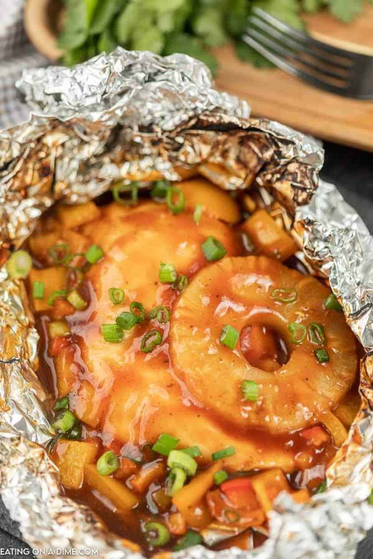 Foil Packet Hawaiian BBQ Chicken Recipe is perfect for the grill, campfire, or oven.  Everyone will love the combination of sweet and tangy. 