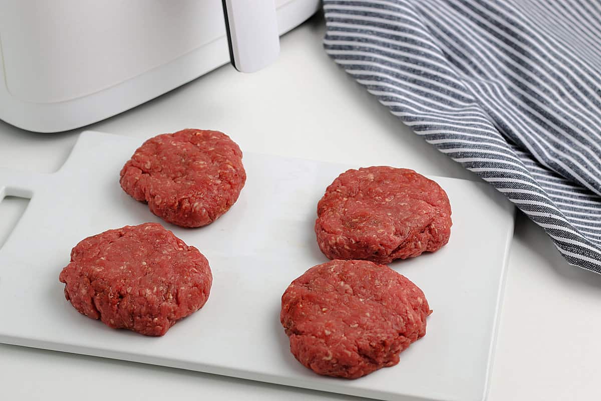 Ground beef patties on a cutting board
