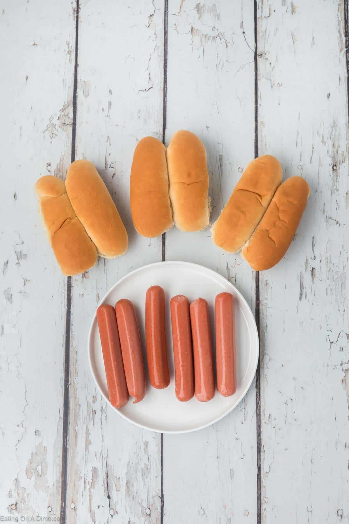 Hot dogs buns and a plate of hot dogs