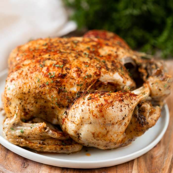 Close up of a Rotisserie Chicken on a white plate  