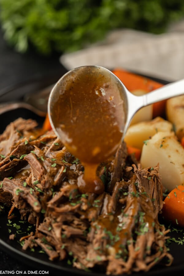plate of roast with gravy and carrots and potatoes 