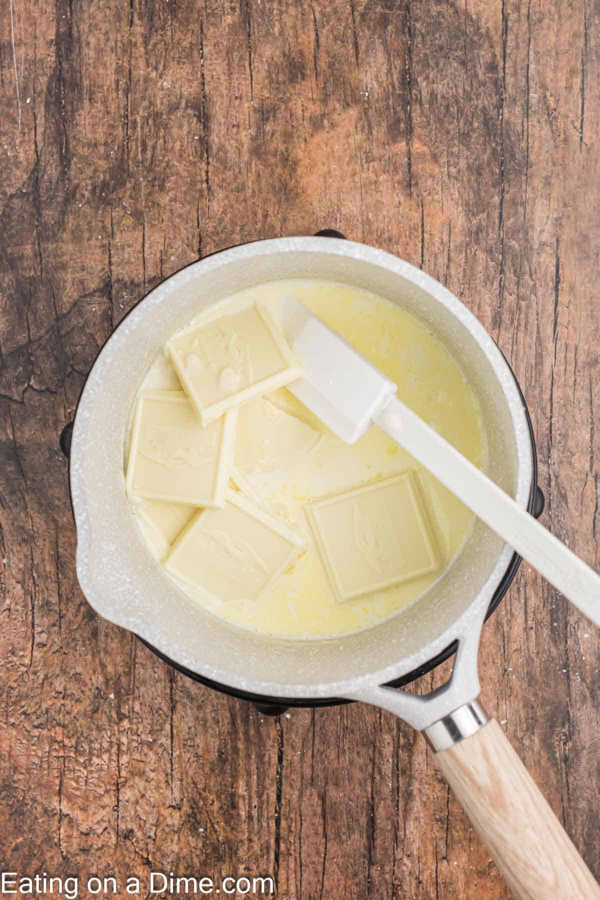 Adding white chocolate in a saucepan